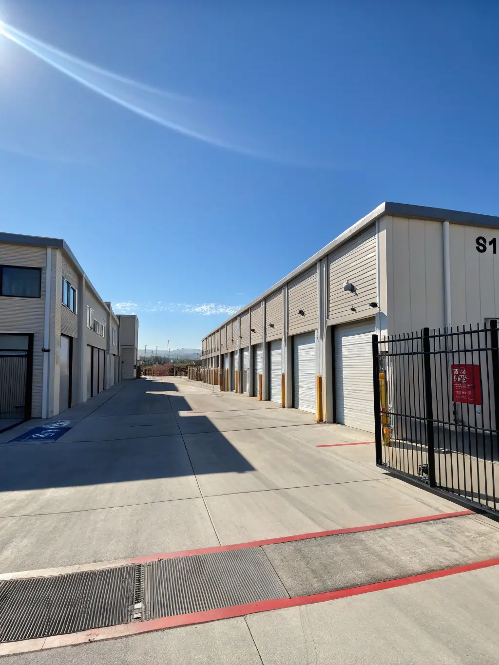 A secure storage facility entrance with visible security cameras and a gated access point, emphasizing the safety and monitoring of the facility.